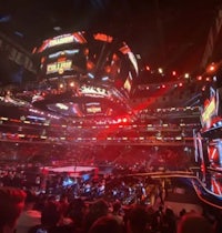 a large arena with many people watching a wrestling match