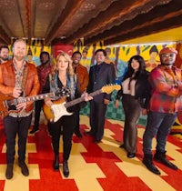 a group of people posing with guitars in a colorful room