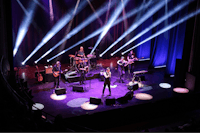 a band performs on stage in front of bright lights